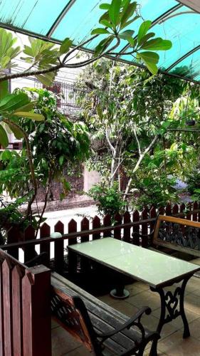 曼谷Jirapong apartment的温室里一张绿桌和一张长椅