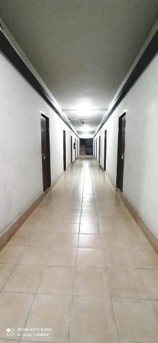 曼谷Jirapong apartment的空的走廊,有门,铺着瓷砖地板