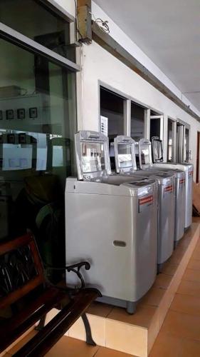 曼谷Jirapong apartment的大楼里的一排洗衣机和烘干机