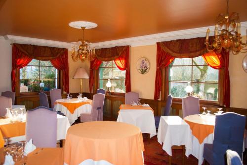 Le Vaudiouxl'Auberge des Gourmets Hôtel Restaurant的用餐室设有桌椅和窗户。
