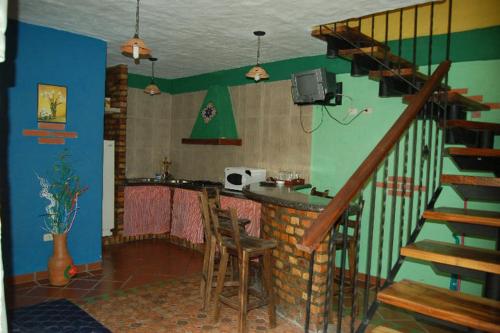 MéridaCabañas Falconia的一间带楼梯的客厅和一间带桌子的酒吧