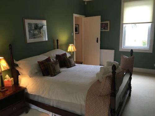 阿罗柴尔Viking Cottage的卧室配有白色大床和绿色墙壁
