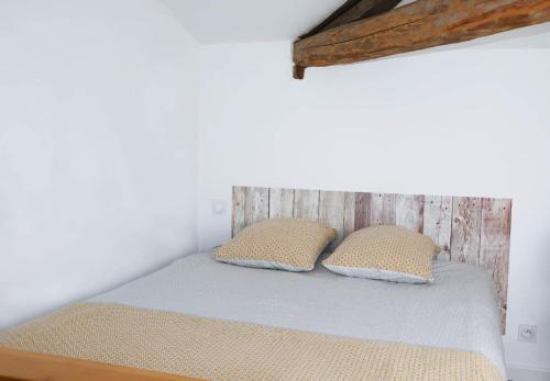 Penne-dʼAgenaisLa Cabane的一张位于房间的床,上面有两个枕头