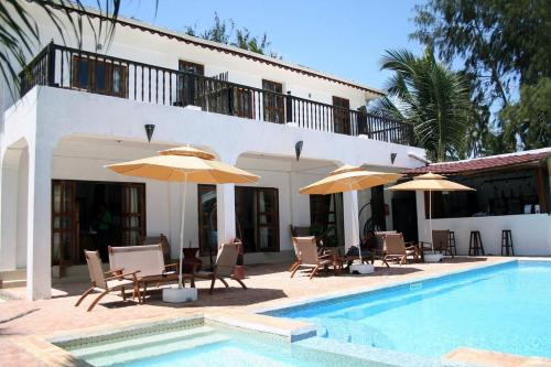 乌罗阿乌罗阿月光精品酒店的别墅 - 带带椅子和遮阳伞的游泳池