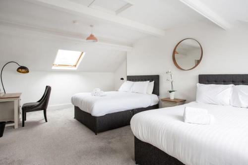 贝尔法斯特Fabulous Penthouse, Brilliant Location, Sleeps 6!的一间卧室配有两张床、一张桌子和一面镜子