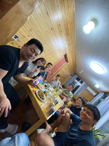 石垣岛ゲストハウス喜舎場的一群坐在桌子旁吃食物的人