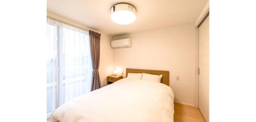富士宫市Rakuten STAY HOUSE x WILL STYLE Fujinomiya 102的一间卧室设有一张床和一个大窗户