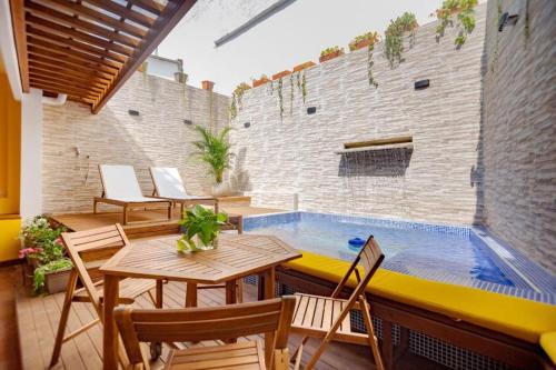 卡塔赫纳Casa Marta by Soho的一个带桌椅的庭院和一个游泳池