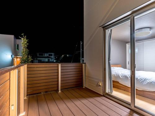 高崎Rakuten STAY HOUSE x WILL STYLE Takasaki 102的客房设有阳台、床和窗户。
