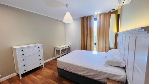 十月六日城Sodic Westown Residence 2的卧室配有白色的床和梳妆台。