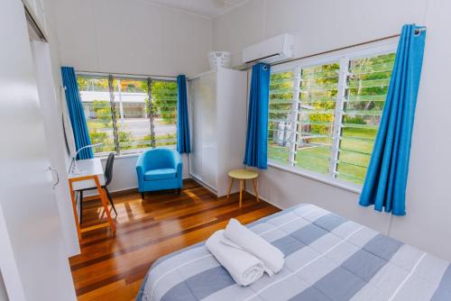 阿卡狄亚科阳7号公寓的一间卧室配有床和2个带蓝色窗帘的窗户。