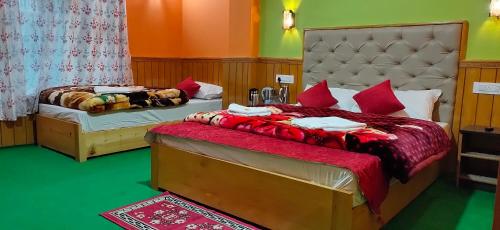 拉冲The Lachung Inn的一间卧室配有两张带红色枕头的床