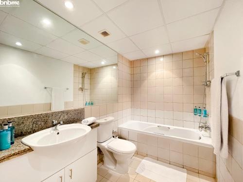 迪拜bnbmehomes - Spectacular 1BR - Community View - 302的浴室配有卫生间、盥洗盆和浴缸。