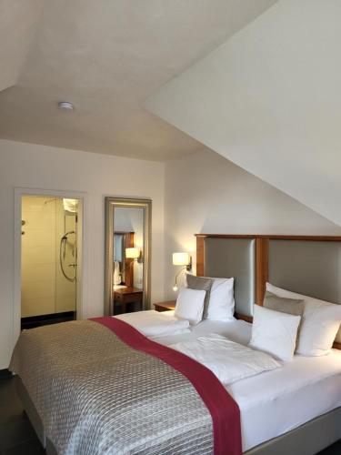 拜尔施泰因Hotel Restaurant Alte Stadtmauer的卧室配有白色大床和白色枕头