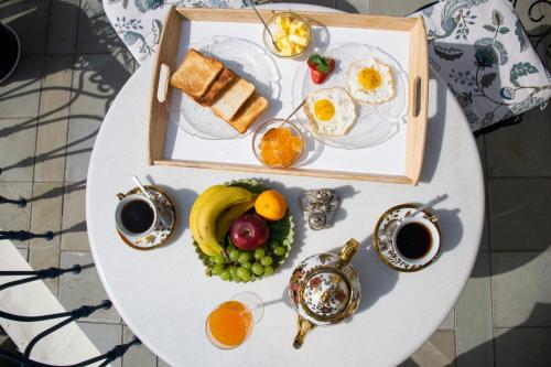 斋浦尔Dileep Kothi - A Royal Boutique Luxury Suites in Jaipur的一张桌子,早餐包括鸡蛋和水果