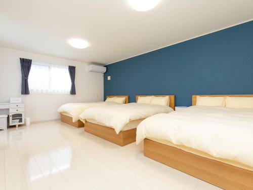 日光Kinugawa Station Front room D的蓝色墙壁客房的两张床