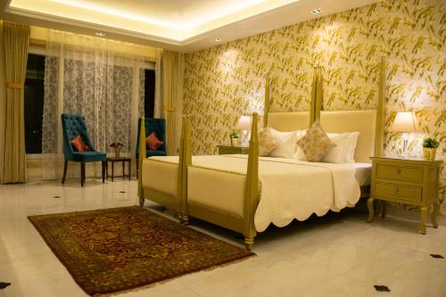 斋浦尔Dileep Kothi - A Royal Boutique Luxury Suites in Jaipur的一间带大床的卧室和一间带椅子的房间