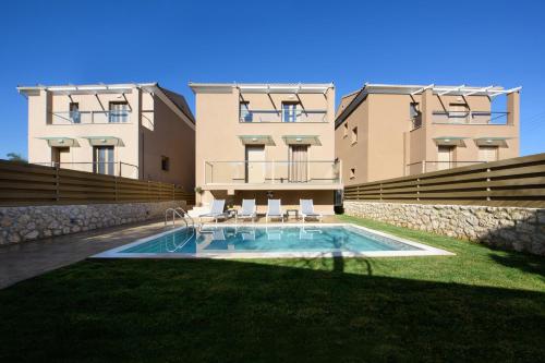 科孚镇Efilenia Luxury Villas的建筑前的一座带游泳池的建筑