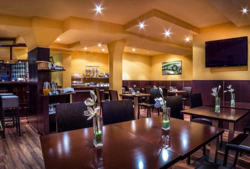 斯图加特维尔慕斯普拉兹酒店的餐厅设有桌椅和平面电视。