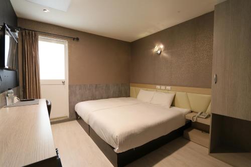 高雄兆舍行旅的一间小卧室,配有床和窗户