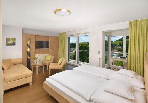 阿尔戈伊地区伊斯尼林德霍厄酒店的卧室配有一张白色的大床和一张沙发。