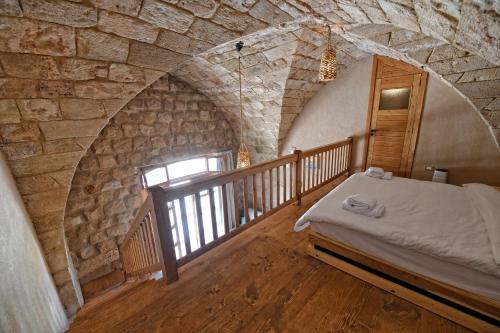 拜特龙Old Town Guesthouses的一间卧室设有一张床和石墙