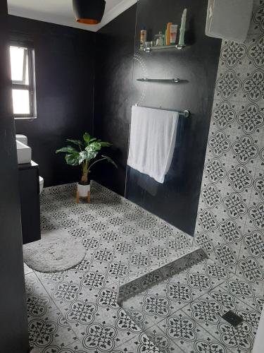 开普敦White house的浴室设有黑色和白色瓷砖和淋浴。