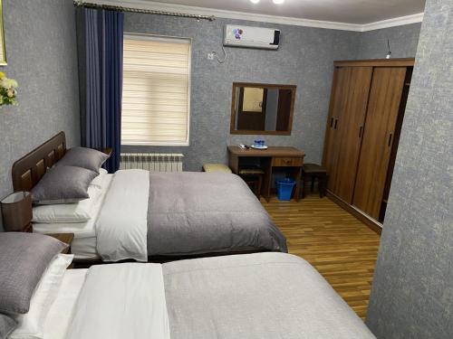 撒马尔罕Cinzano Complex的一间卧室配有两张床和一张书桌