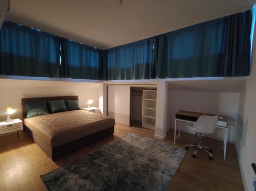 波德戈里察Blue Apartment Riverside的卧室配有一张床、一张书桌和窗户。