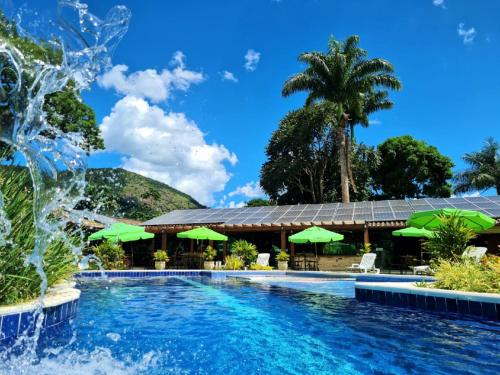 萨纳Pousada Maritacas do Sana的度假村的游泳池,带绿伞
