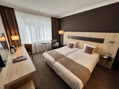 布鲁塞尔最佳西方皇家中央酒店的酒店客房设有一张大床和一张书桌。