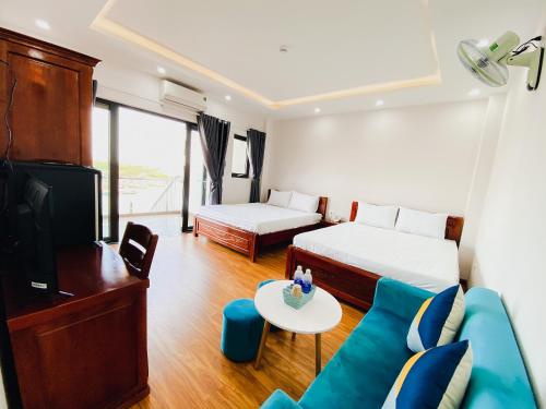 归仁Khách sạn Ngọc Hồi的酒店客房,设有两张床和一张沙发