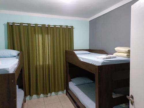 瓜鲁柳斯10 MIN AEROPORTO GUARULHOS的客房设有两张双层床和绿帘