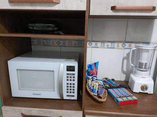 瓜鲁柳斯10 MIN AEROPORTO GUARULHOS的厨房柜台配有微波炉和搅拌机