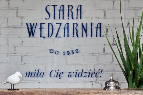 格但斯克Kurort Stara Wędzarnia的坐在标牌前桌边的白鸟