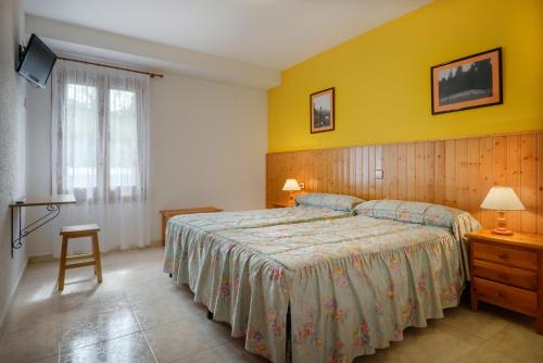 安索Hostal Kimboa的一间卧室设有一张床和黄色的墙壁