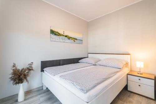 斯图托沃Apartament Baltic Sun N°36的白色卧室配有床和桌子