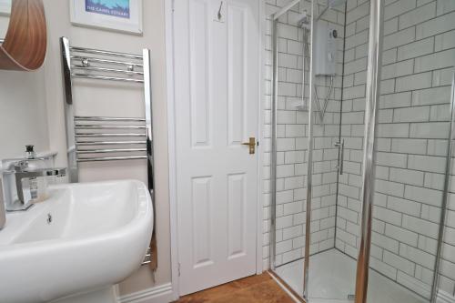 圣梅尔林BY THE BEACH cottage, dogs welcome的白色的浴室设有水槽和淋浴。
