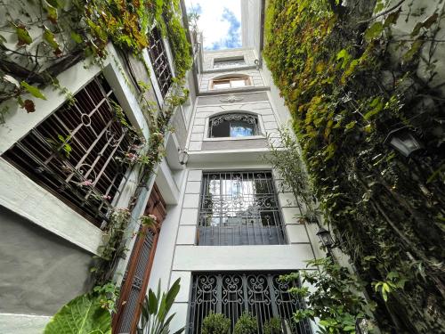 布宜诺斯艾利斯佩蒂帕莱斯住宿加早餐旅馆的一座白色的建筑,里面装有窗户和植物