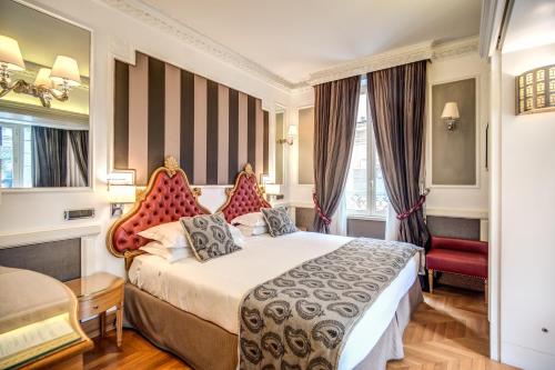 罗马大不列颠酒店的酒店客房,配有一张床和一张红色椅子