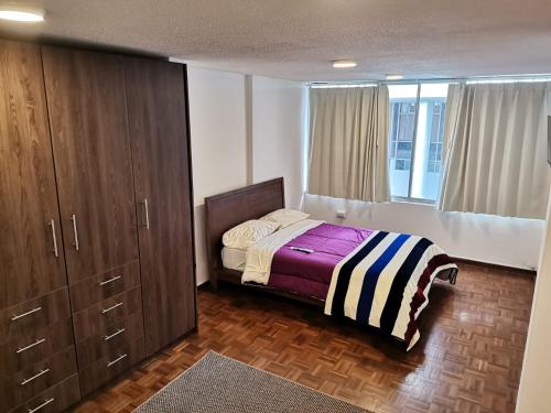 基多Suite Estudio的一间卧室配有一张床和一个大衣柜