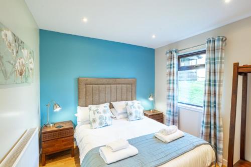 牛顿斯图尔特Birch Lodge的一间卧室配有一张带蓝色墙壁的大床