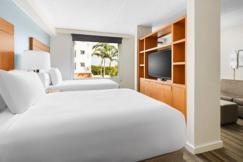 达尼亚滩劳德代尔堡机场/邮轮港凯悦酒店的一间酒店客房,配有一张床和一台电视