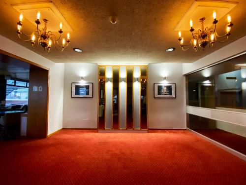 托基Livermead Cliff Hotel的走廊上设有红地毯和玻璃门