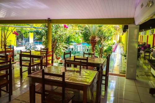 阿鲁阿南水瓶座旅馆的一间带桌椅的餐厅和庭院