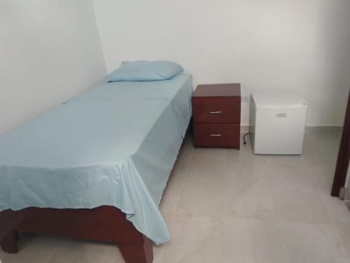 博卡奇卡RECIDENCIAL MIGNOLI的一间卧室配有一张床、梳妆台和床头柜