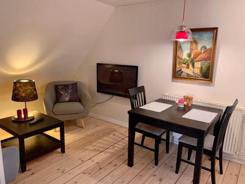 斯凯拜克Jægergård的客厅配有桌子和椅子