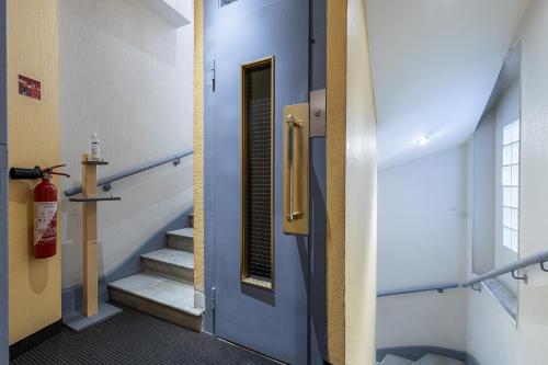 戛纳摩登瓦基酒店的走廊设有蓝色门,楼梯设有灭火器