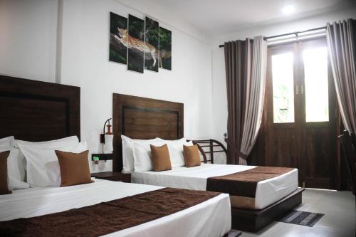 阿努拉德普勒Divine Villa的酒店客房设有两张床和窗户。