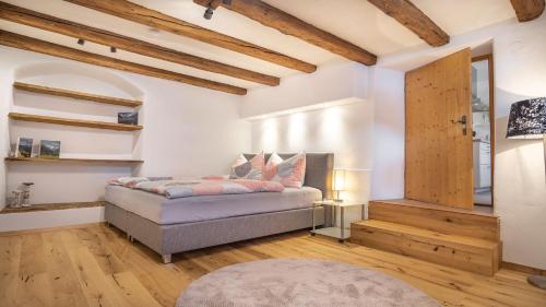 富尔普梅斯StuWip alps Appartement Sonnenstein的一间带一张床的卧室,位于带木制天花板的房间内